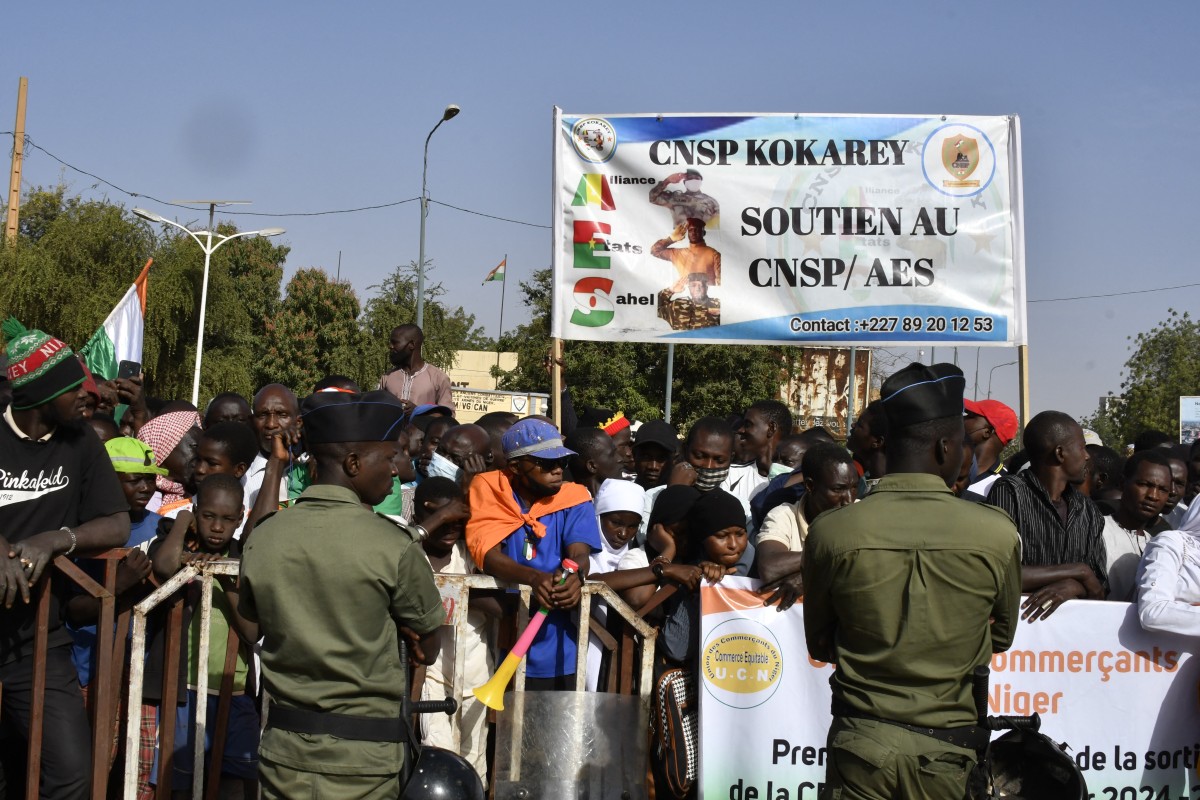 People carry a sign in support of the Alliance of Sahel States (AES) during a gathering to celebrate the withdrawal of Mali, Niger and Burkina Faso from the Economic Community of West African States (ECOWAS) in Niamey on January 28, 2025. Photo by Boureima Hama / AFP)