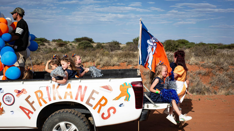 An Afrikaner cheerleading group looks at onlookers during a parade @ Per-Anders Pettersson/Getty Images