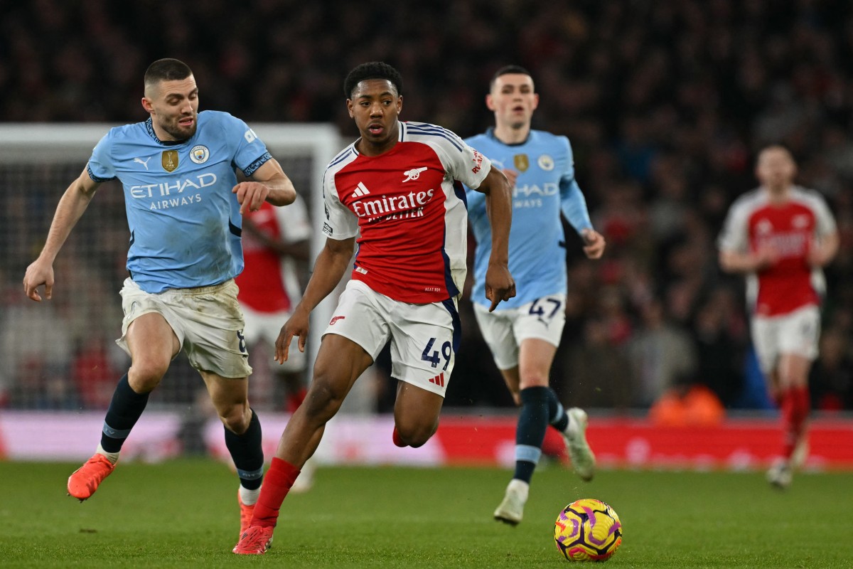 Arsenal’s English midfielder #49 Myles Lewis-Skelly (C) runs with the ball during the English Premier League football match between Arsenal and Manchester City at the Emirates Stadium in London on February 2, 2025. (Photo by Glyn KIRK / AFP) /